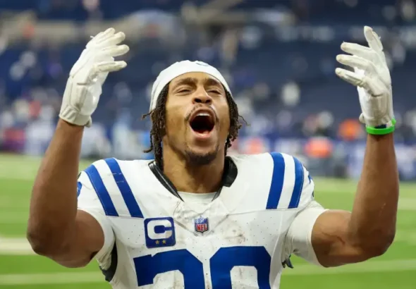 Jonathan Taylor Contract Extension Keeps Colts Star in Indianapolis Jonathan Taylor in Indianapolis Colts white jersey number 28 celebrating with both arms raised after agreeing to new contract extension