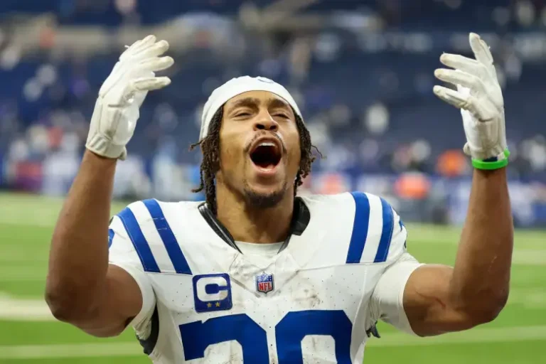 Jonathan Taylor Contract Extension Keeps Colts Star in Indianapolis Jonathan Taylor in Indianapolis Colts white jersey number 28 celebrating with both arms raised after agreeing to new contract extension