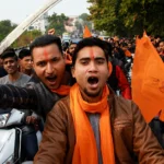 Hindu Extremist supporters riding motorcycles with saffron flags during a street rally in India amid debate over RSS outreach and rising hate crimes against minorities